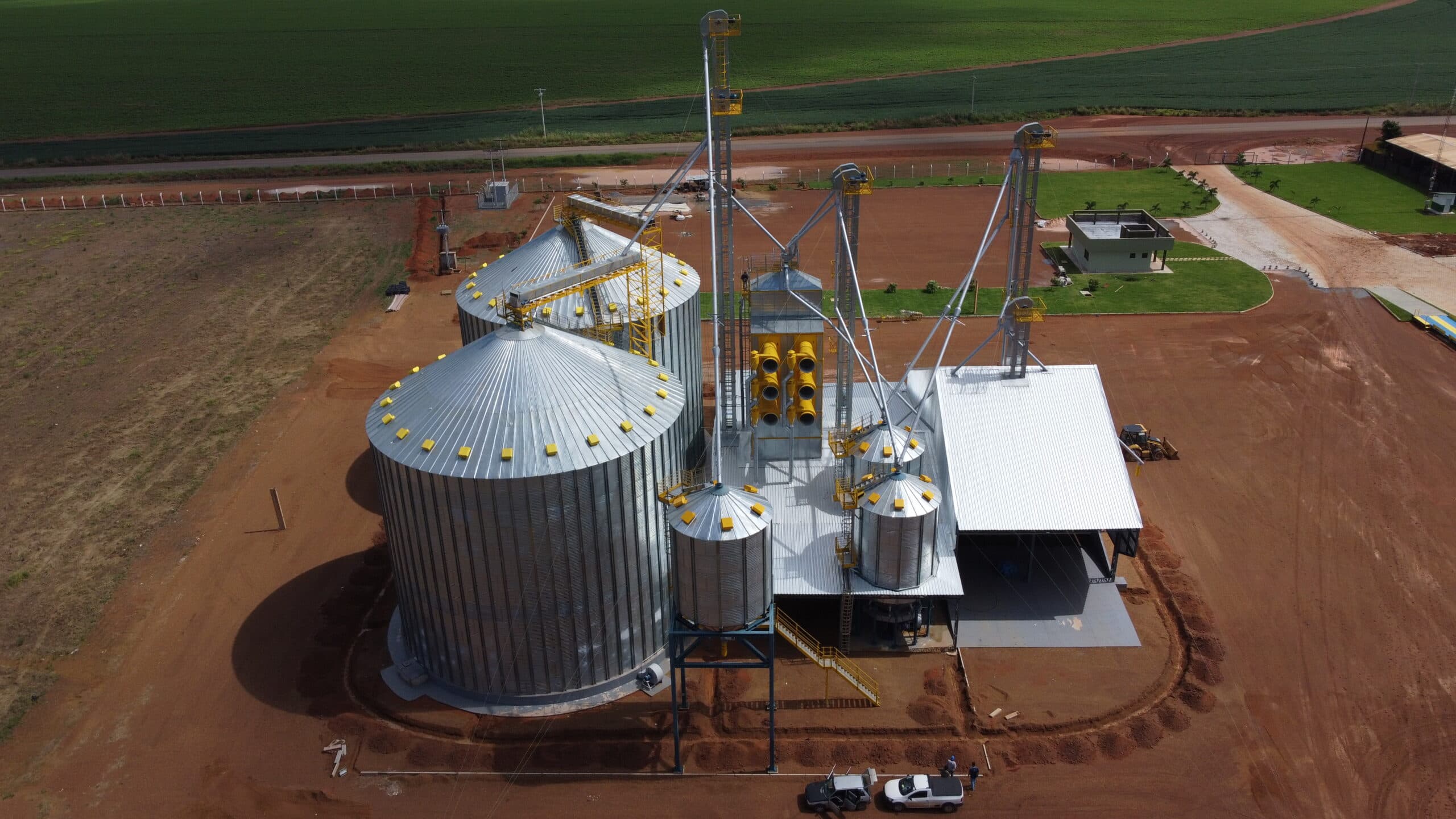 Vista aérea próxima de silos metálicos com detalhes amarelos